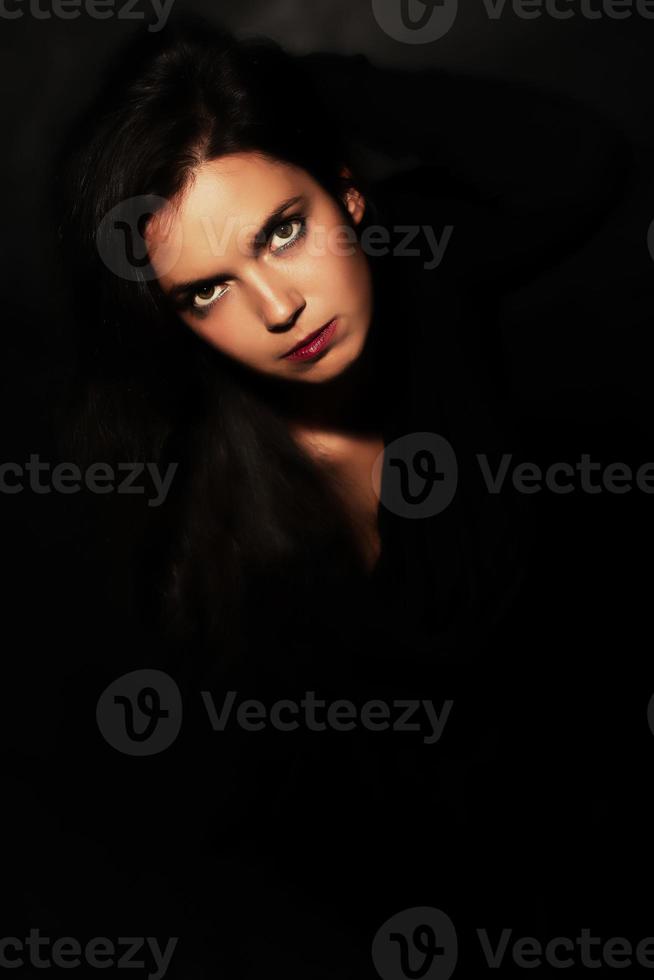 Portrait of black woman in black on a black background photo