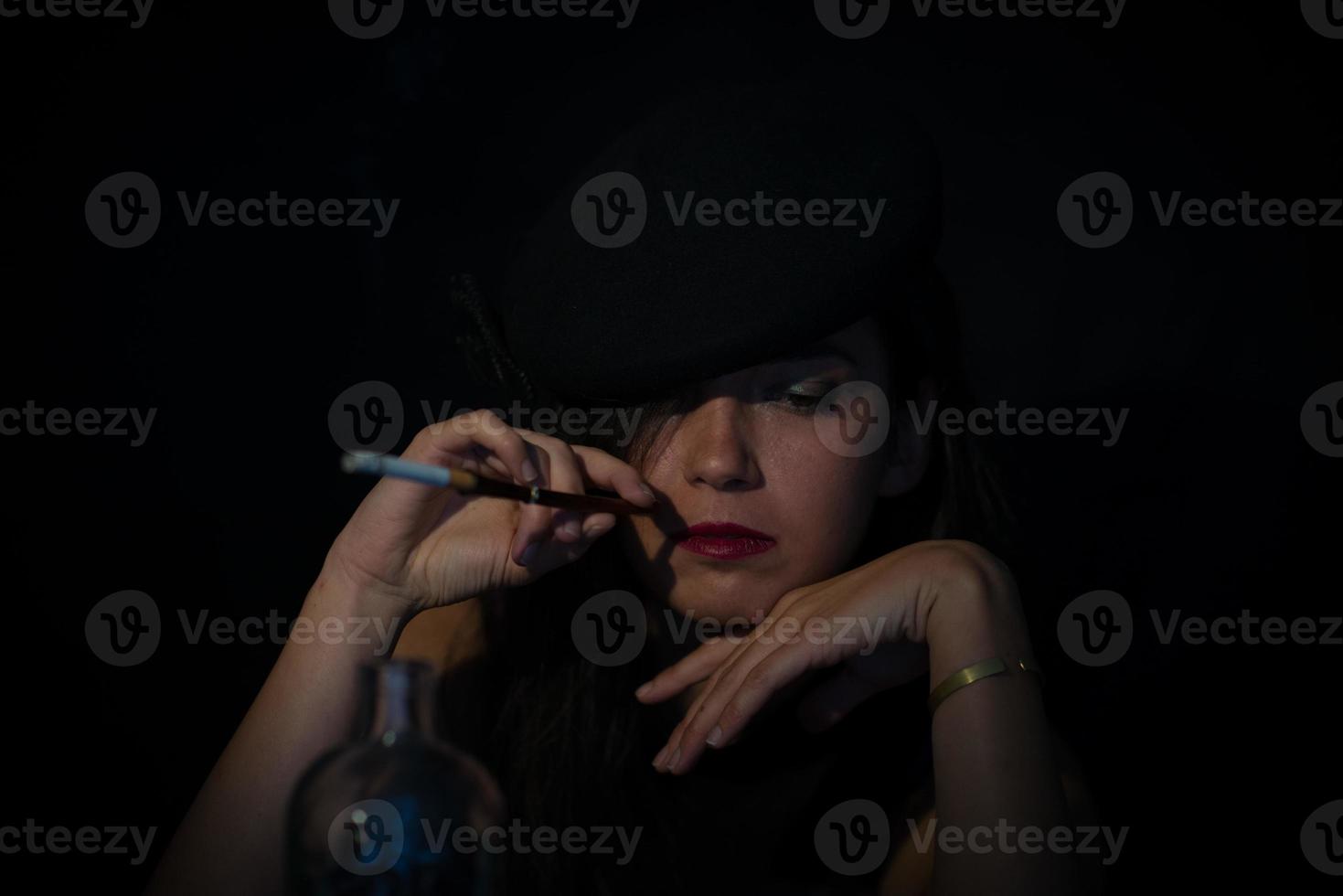 Retro woman with mouthpiece cigarette and alcohol. retro style photo
