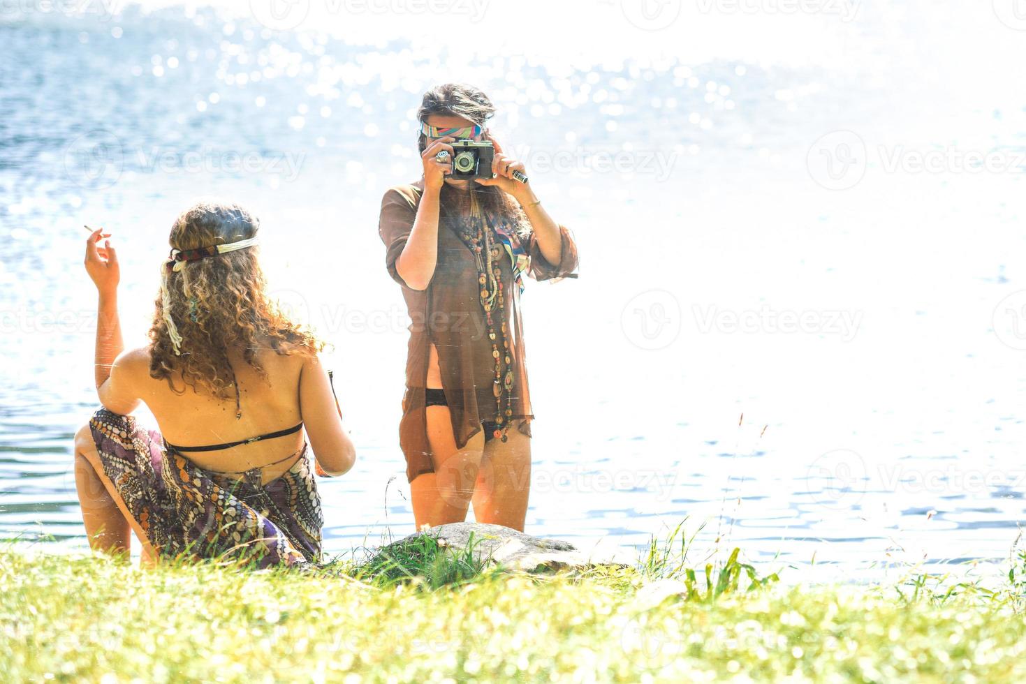 Hippie girls taking photos with an old camera and smoking - Vintage effect photo