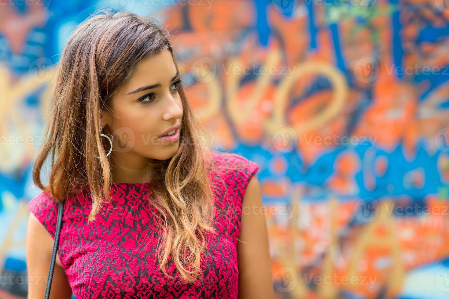 chica adolescente, hermosa en un retrato frente a un mural colorido foto