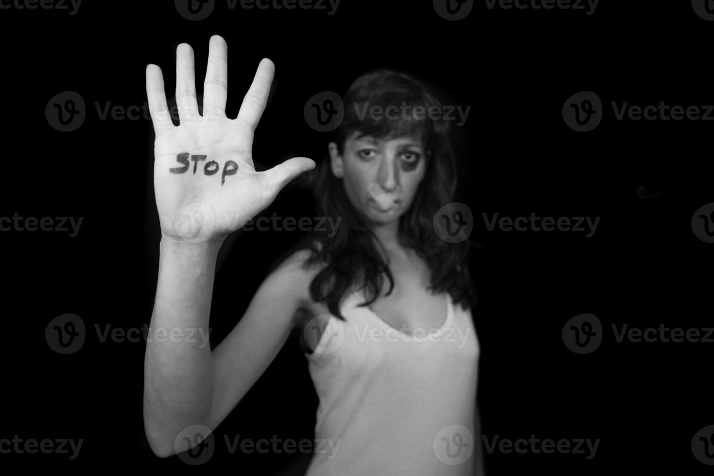 Stop violence against women. Woman with mouth closed by patch and hand written stop photo