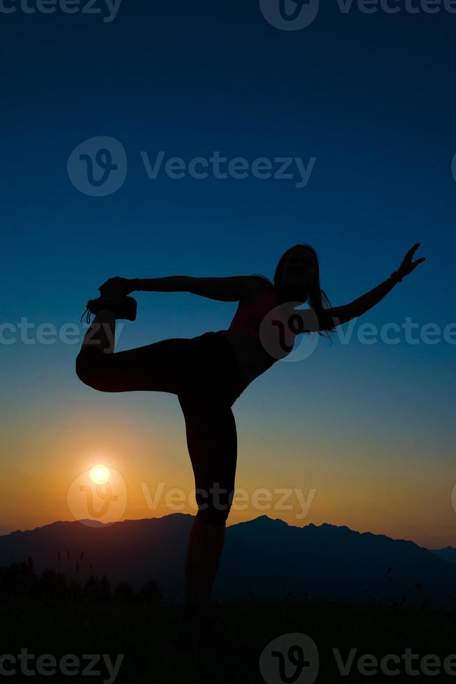 Silhouette of woman at sunset in the mountains photo