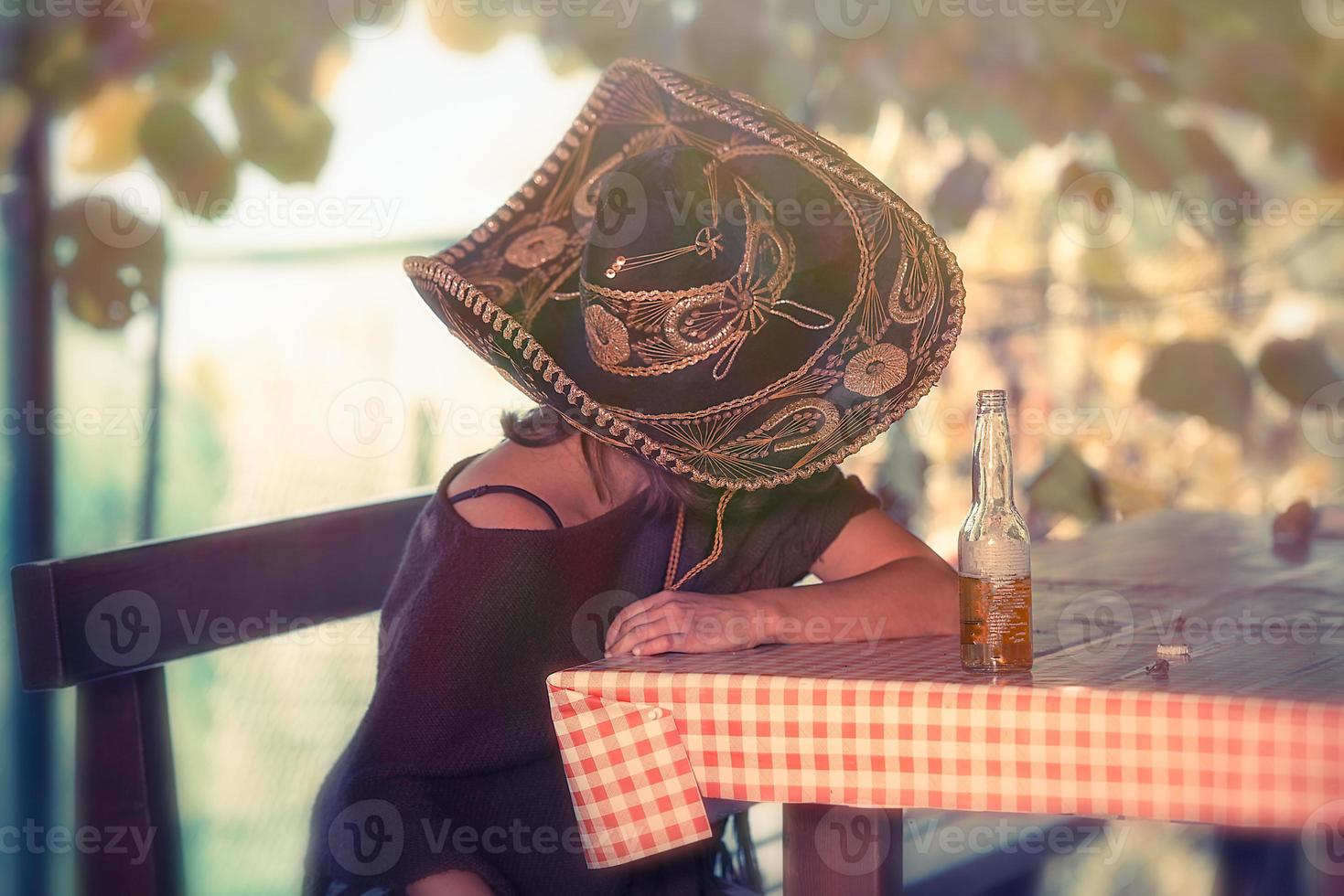 mujer mexicana durmiendo apoyada en la mesa foto