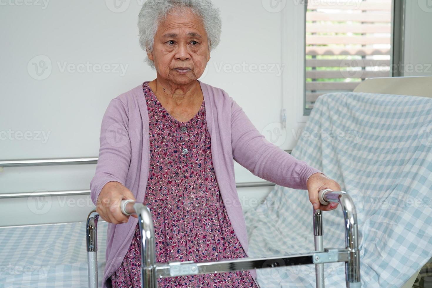 anciana asiática discapacitada paciente camina con andador en el hospital de enfermería, concepto médico. foto