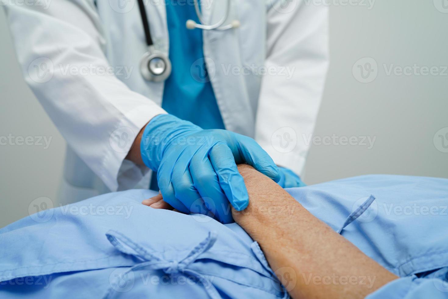 médico tomados de la mano paciente anciana asiática, ayuda y atención en el hospital. foto