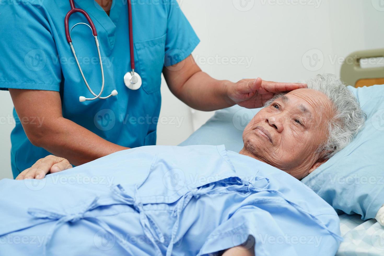 Asia doctor with stethoscope checking elderly woman patient in hospital, healthy medical concept. photo