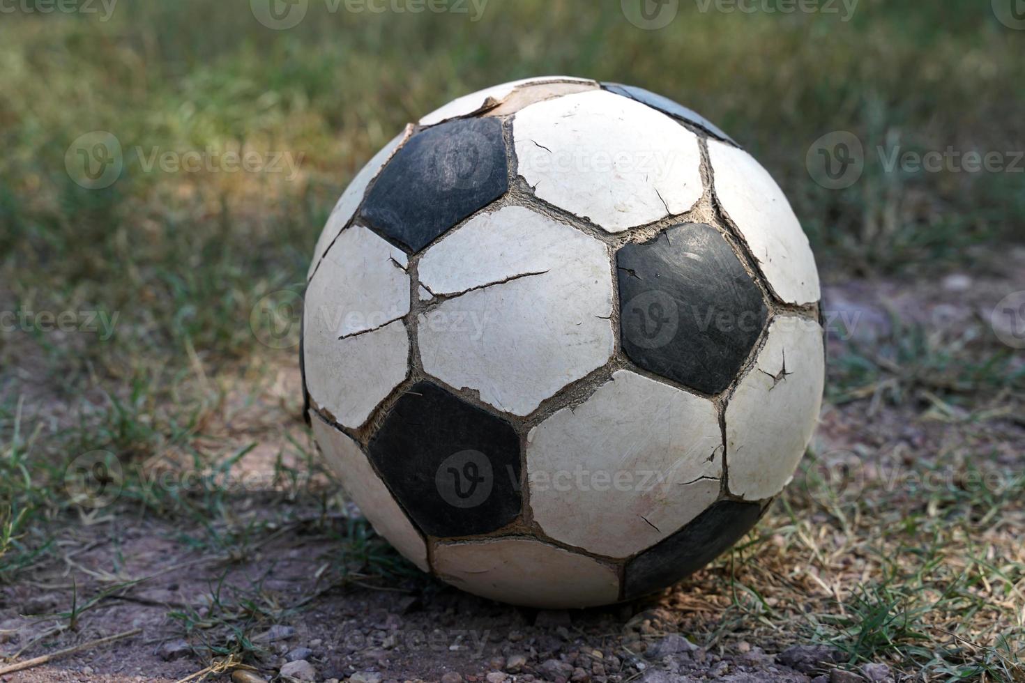 viejo balón de fútbol, cuero agrietado pero los estudiantes rurales tailandeses lo usan para jugar en el campo durante sus descansos. enfoque suave y selectivo. foto