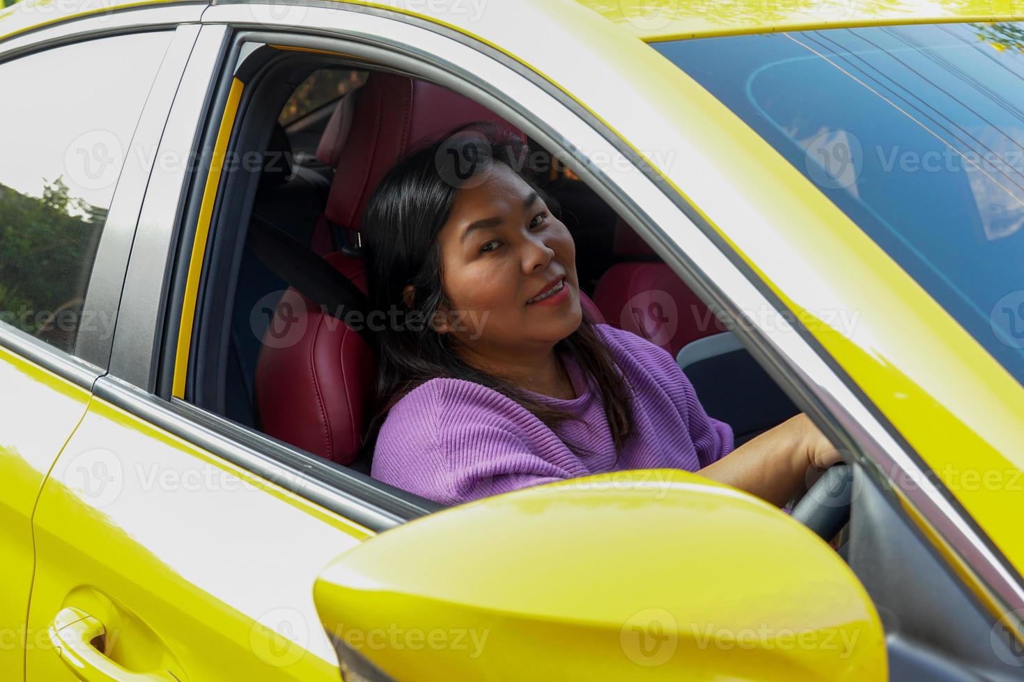 happy smiling asian woman drive a bright yellow car go on holiday. Soft and selective focus. photo