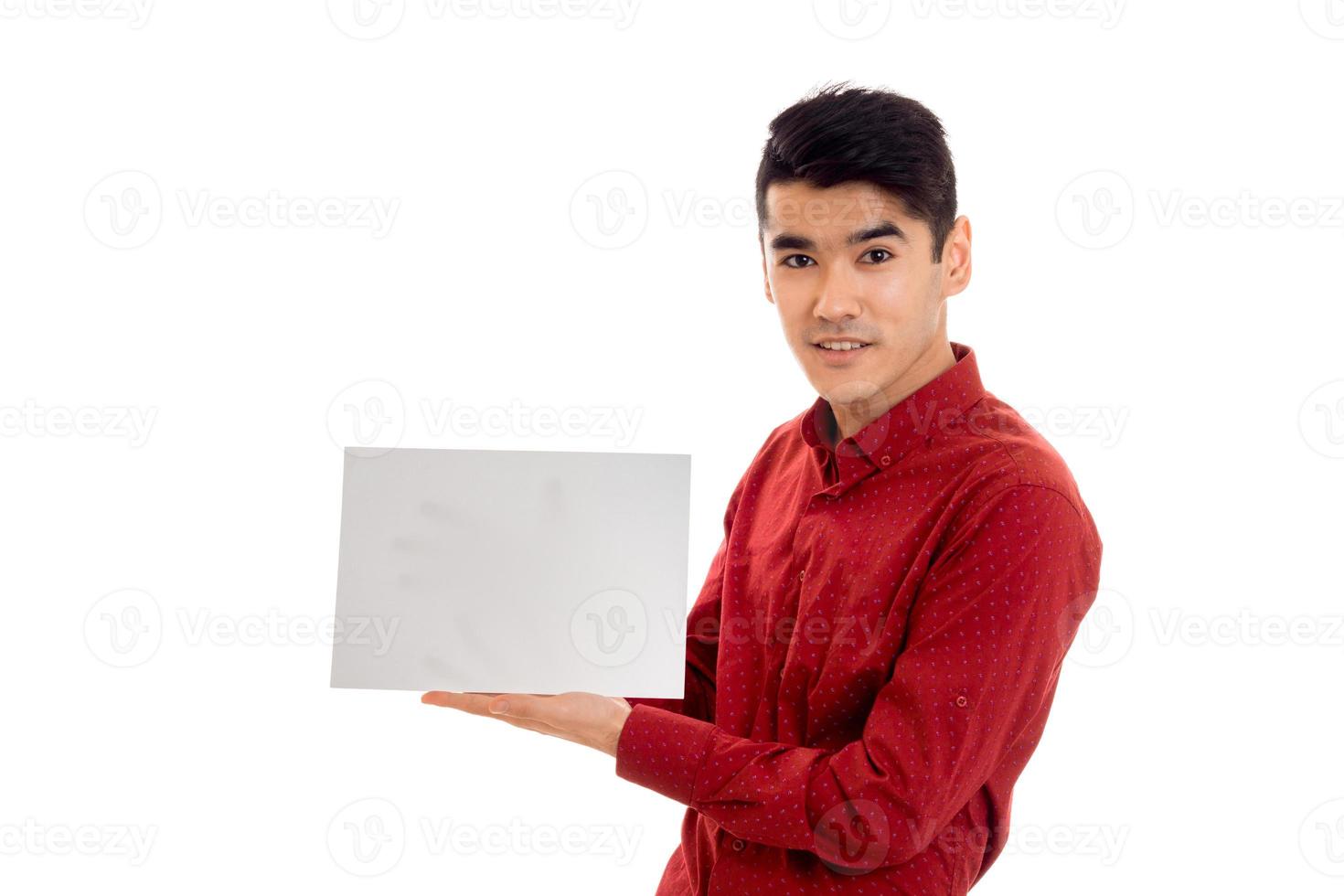 elegante modelo masculino moreno con camisa roja posando con una pancarta vacía aislada de fondo blanco foto