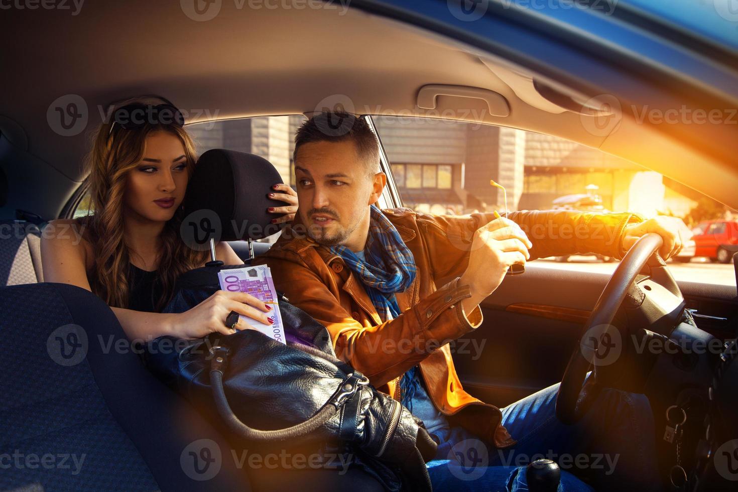 man talking to a young woman in a car with a bag full of money EUR photo