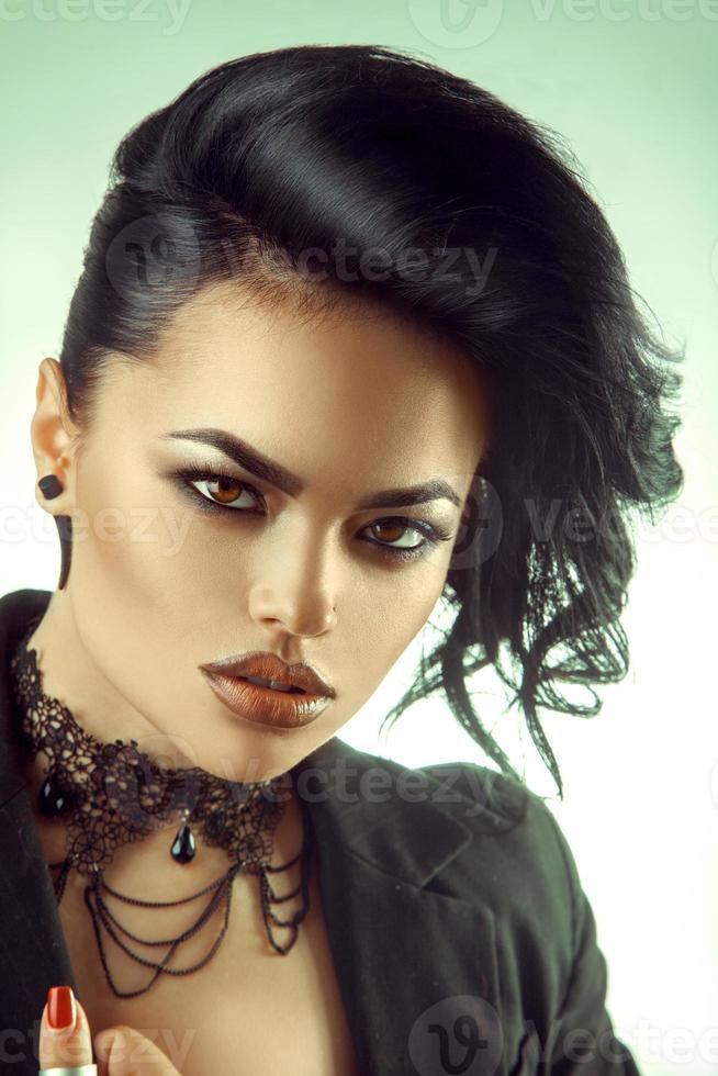 Beautiful brunette looking at camera with make up and hairstyle photo