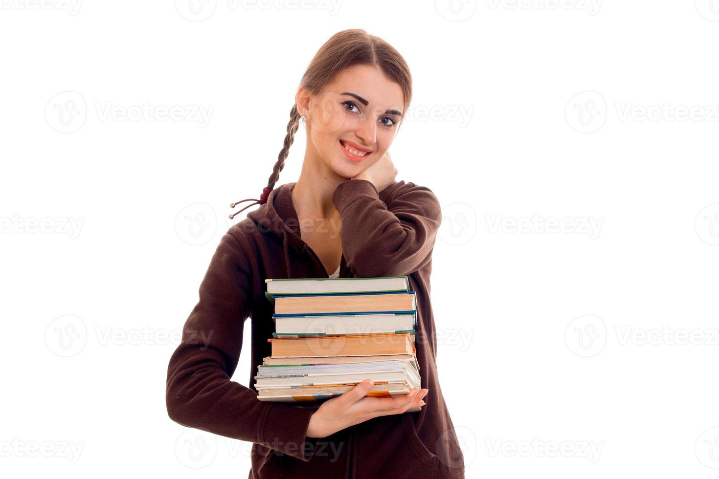 linda jovencita con coletas sonriendo y sosteniendo un libro en sus manos foto