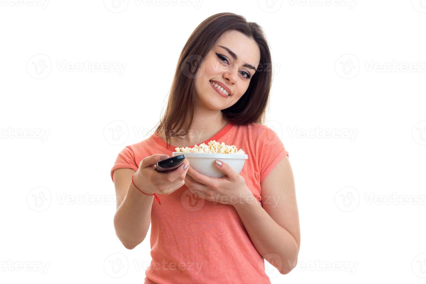 Cutie cheerful girl with pop-corn watching a tv photo