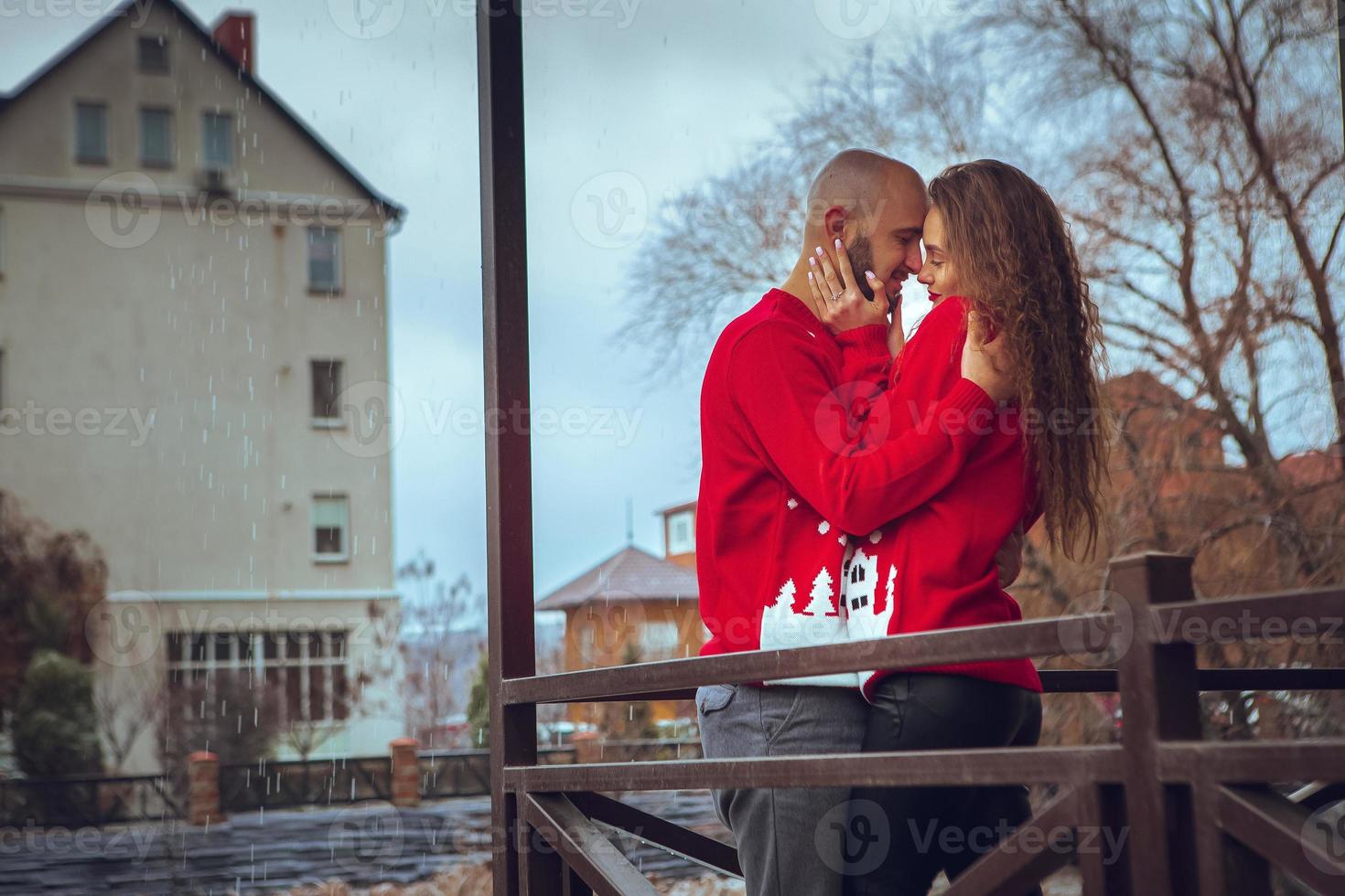 Una pareja sexy enamorada se abraza en un balcón en invierno. foto