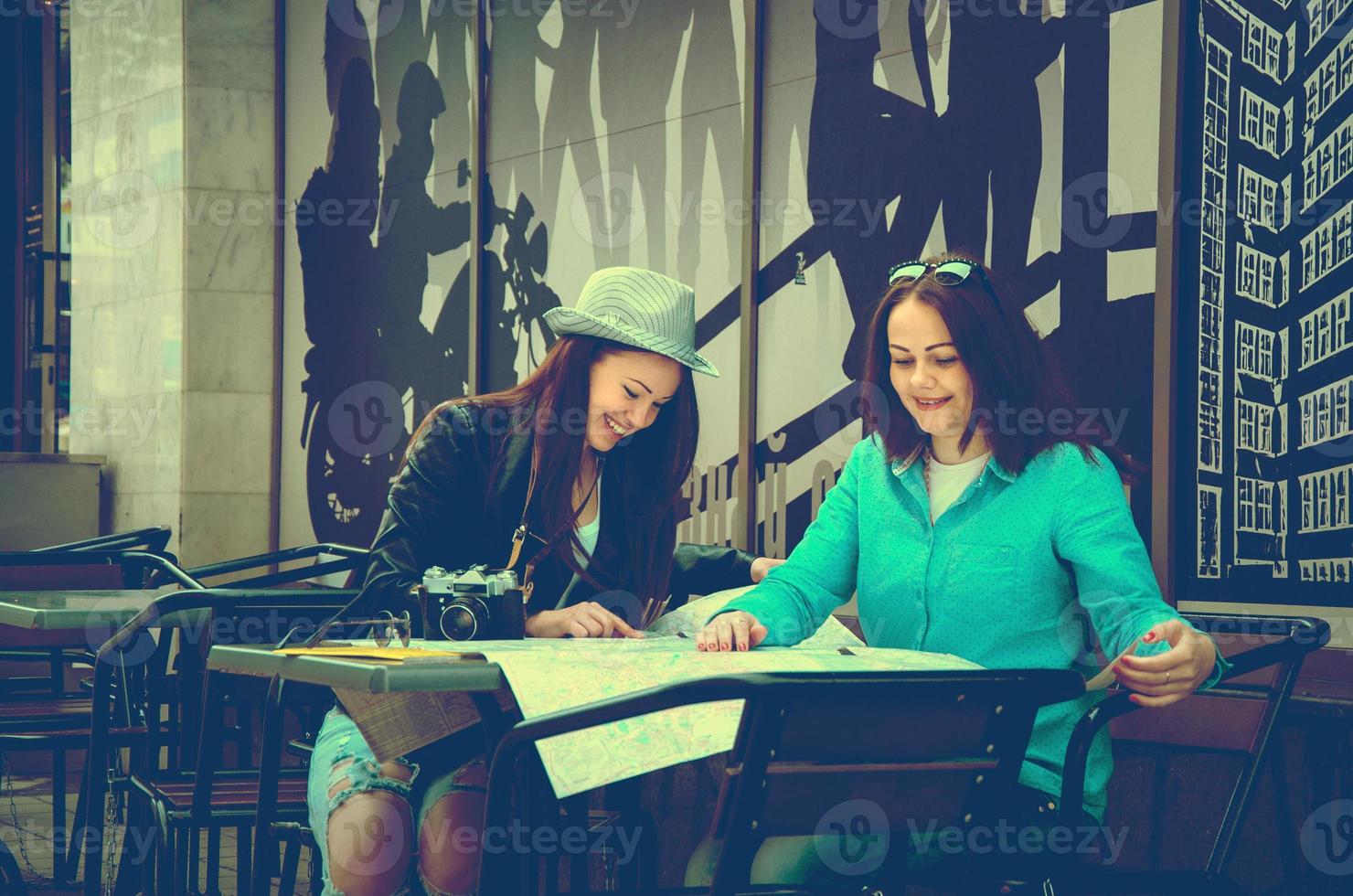 two women sitting at a table on the street photo