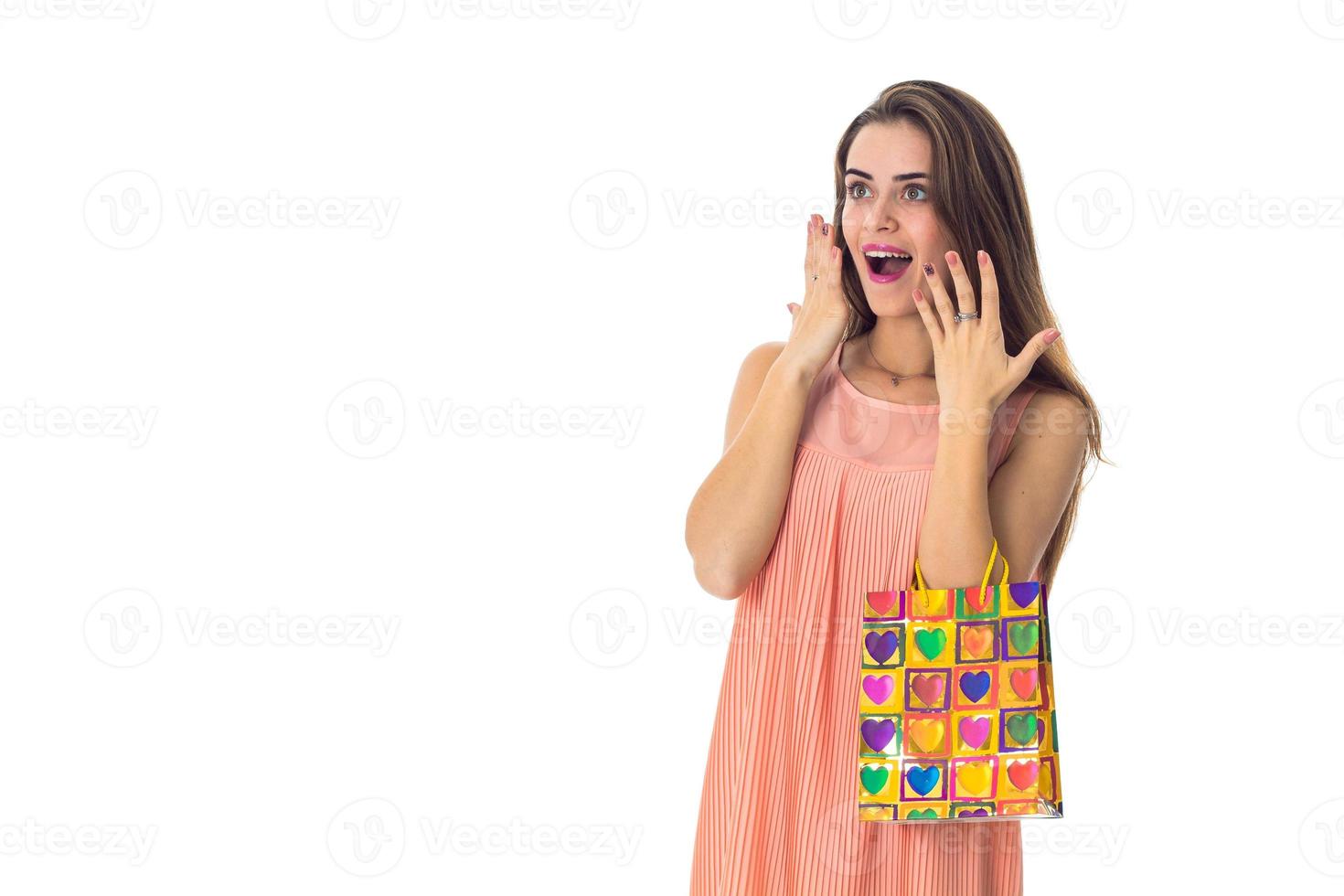 happy surprised girl holding a colorful package isolated on white background photo