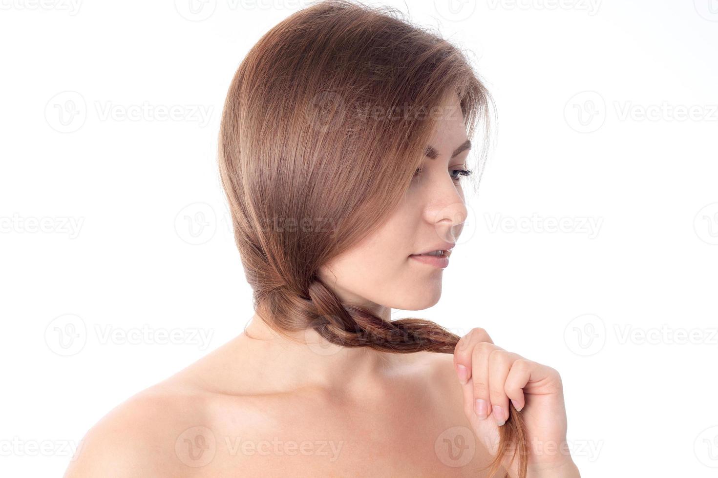 a young girl holds her pigtail hand isolated on white background photo