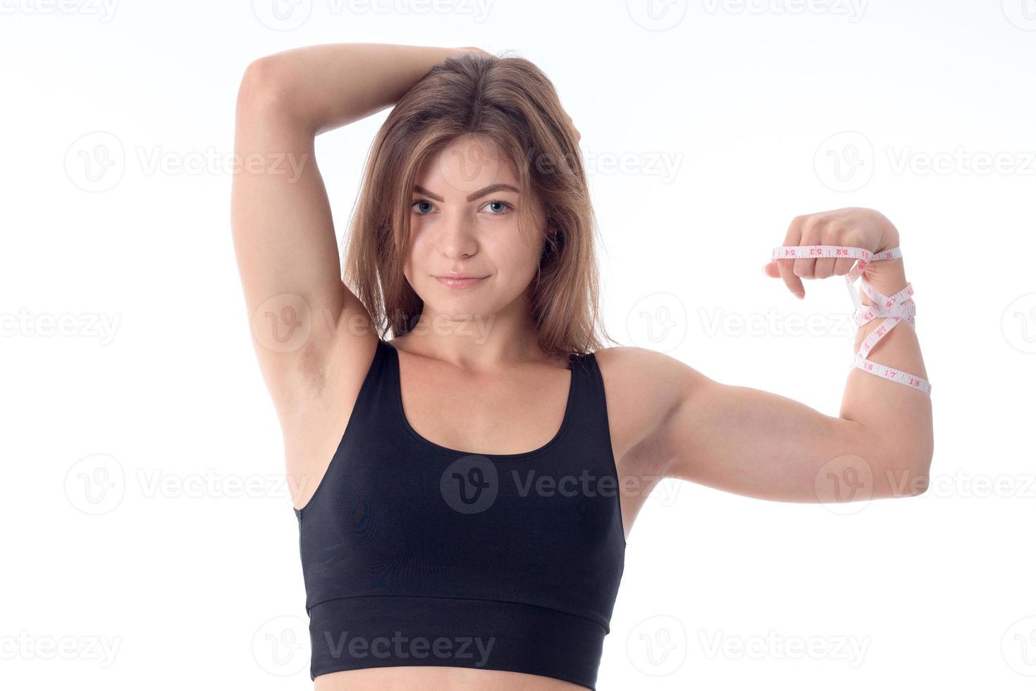 close-up of a beautiful slender athletic girl who smiles and shows his muscles photo