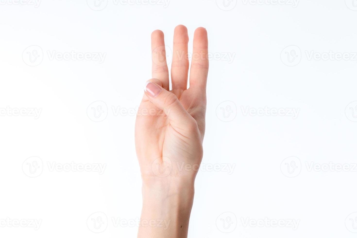 female hand stretched up and showing three fingers isolated on white background photo