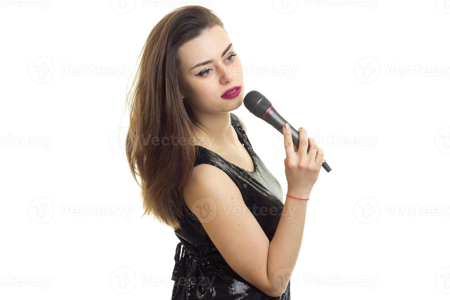 señorita en vestido negro con micrófono foto