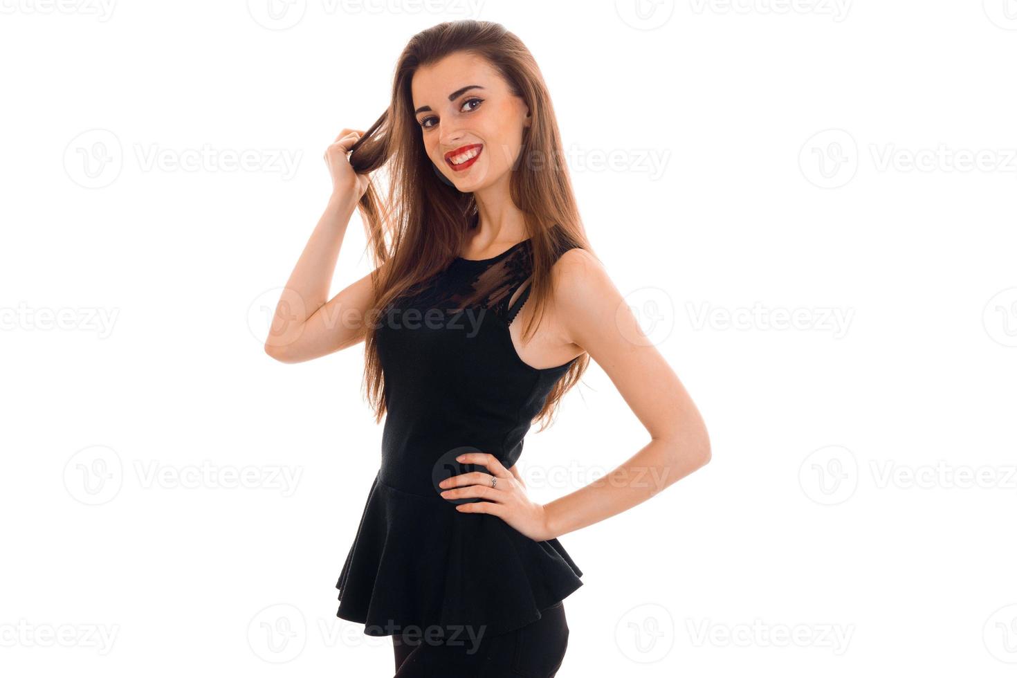 beautiful young girl in a black dress laughs and looks into a camera photo