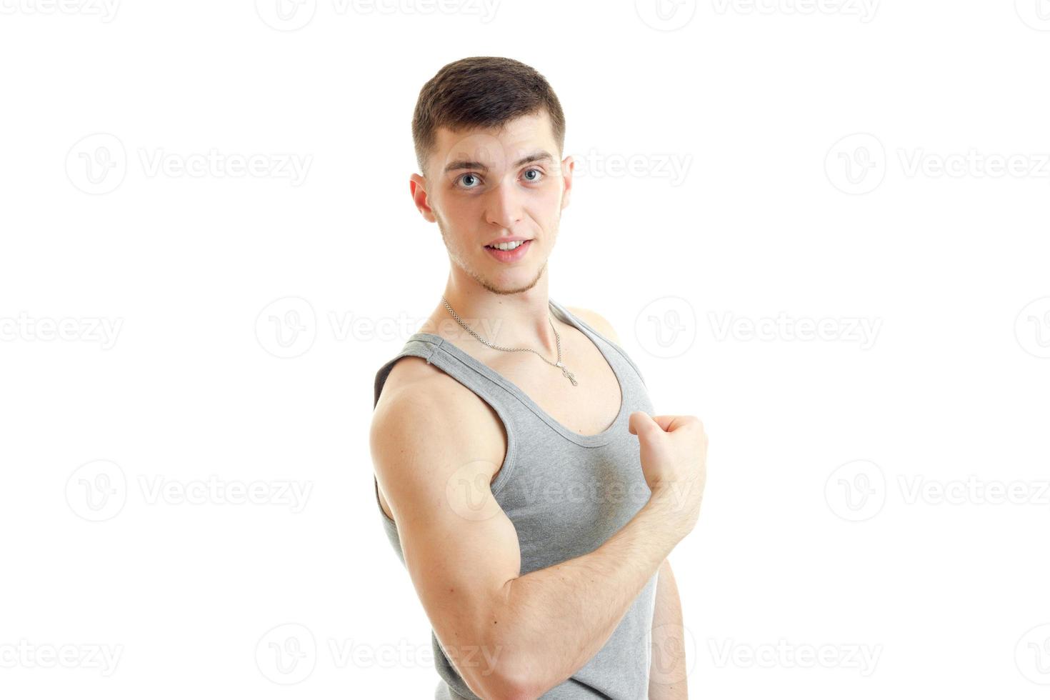 wonderful Sports Guy shows the muscles of the hand and smiles looks at camera photo