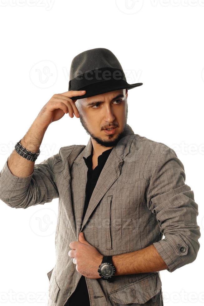 young handsome unshaved man in hat and jacket looking away photo