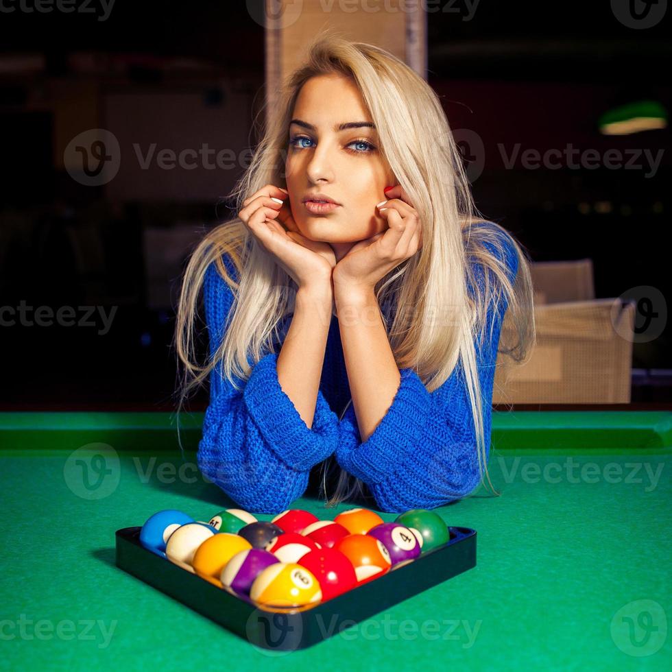 Portrait of young beautiful blonde girl with pyramid of pool balls photo
