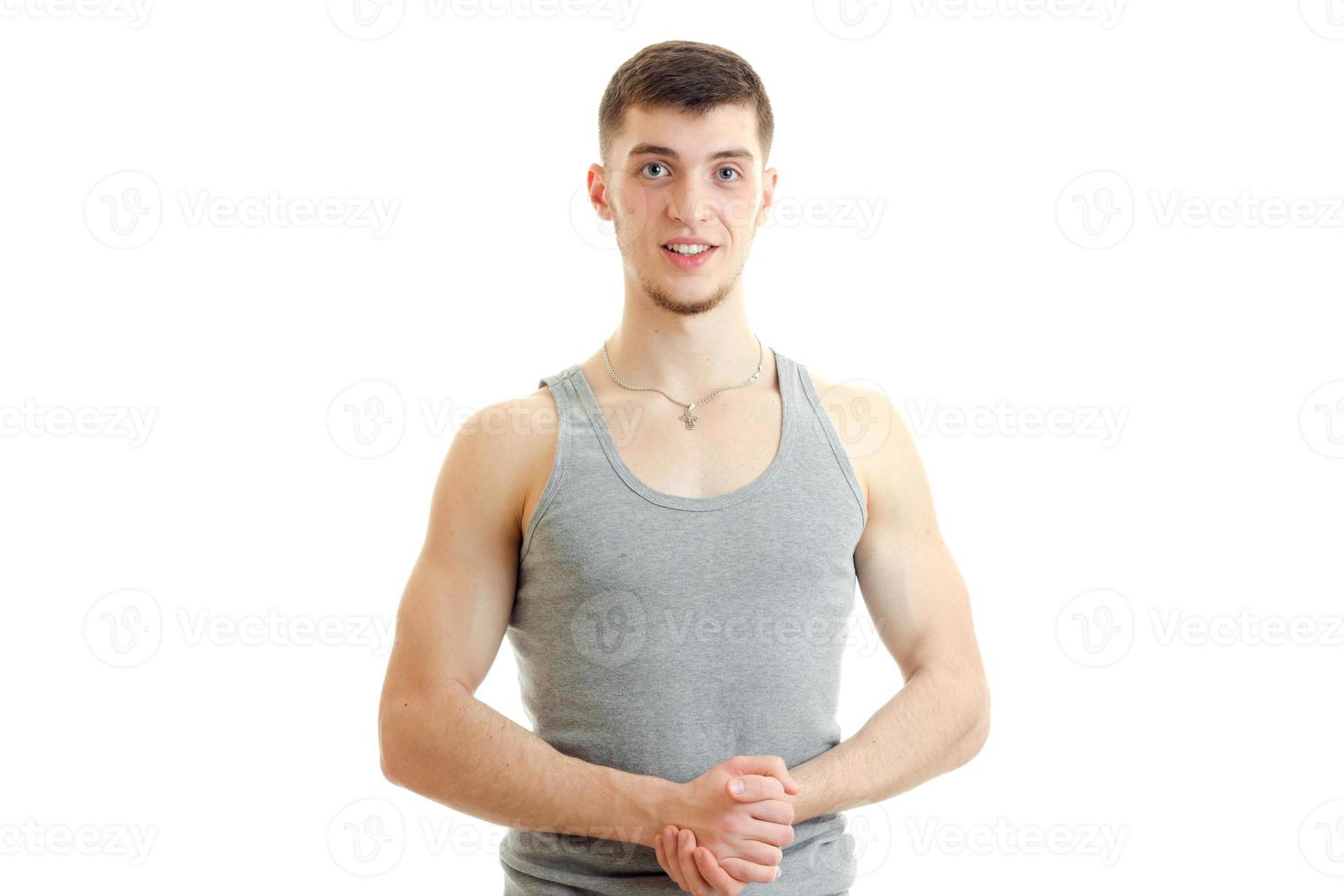 charming young guy standing in the grey t-shirt looks forward and smiling photo