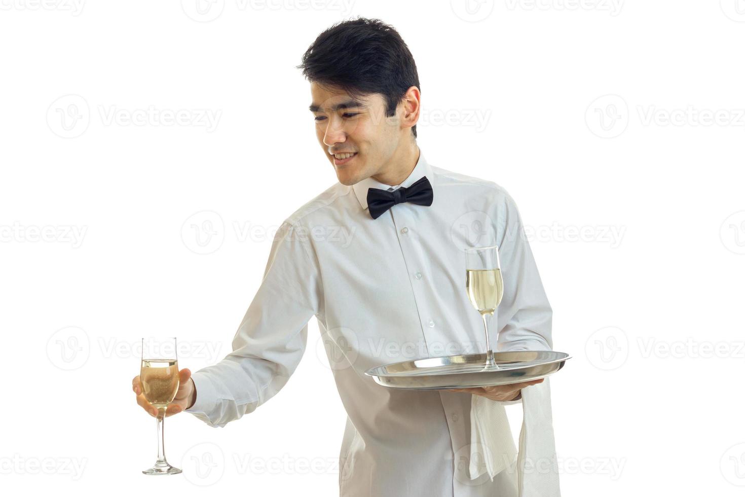 handsome waiter in a white shirt and with a butterfly stretches glass of wine photo