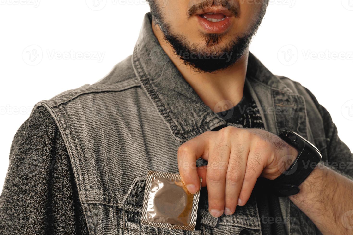 man gets out a condom of his pocket photo