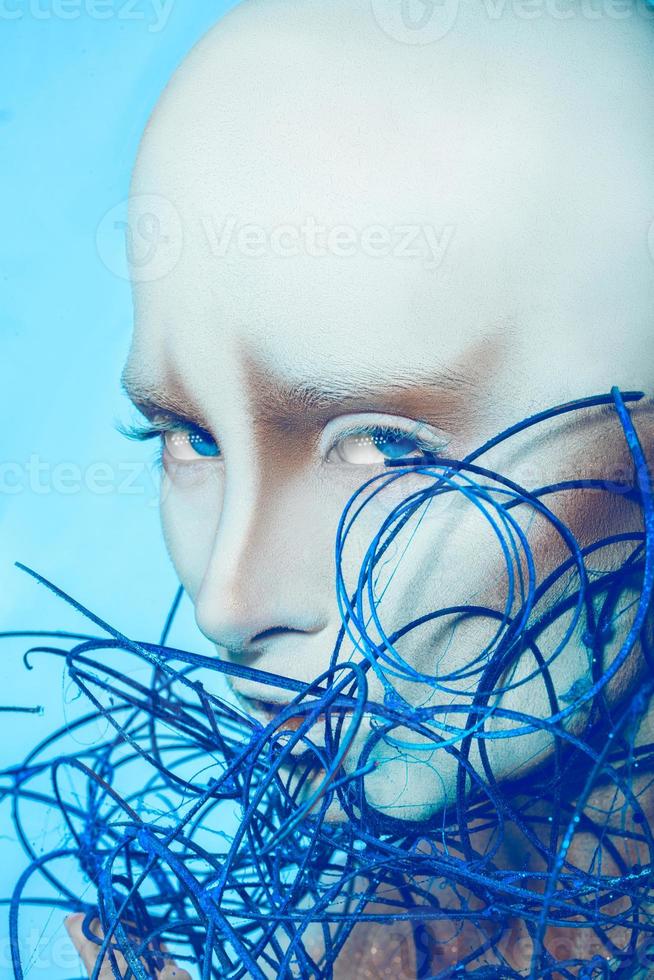 atractiva mujer calva con arte corporal sobre fondo azul foto