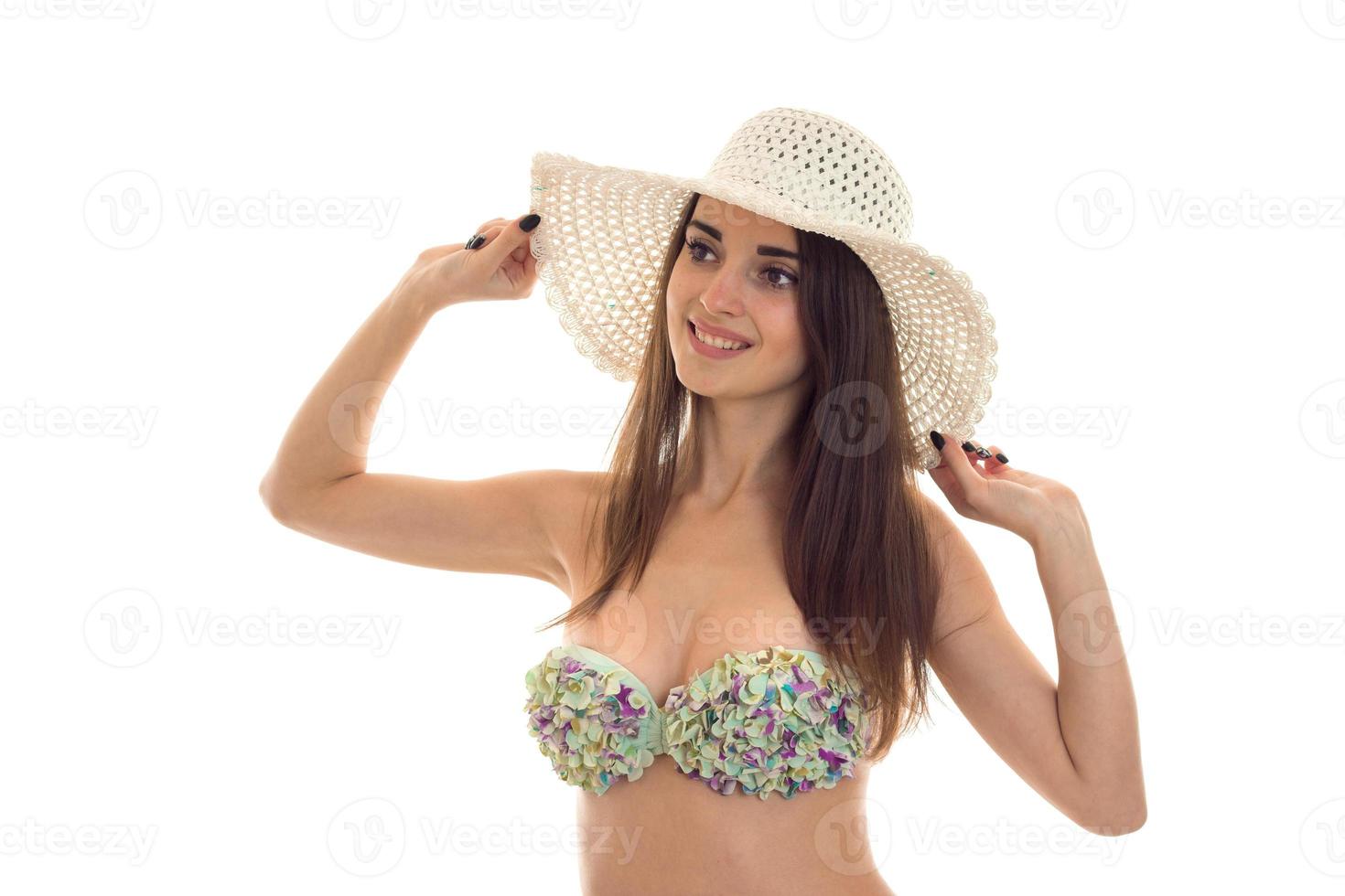happy slim young lady with big natural breasts in swimsuit with floral pattern and straw hat with wide brim smiling isolated on white background photo