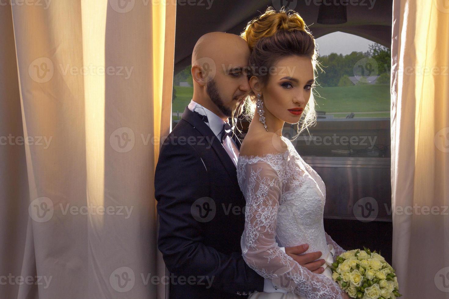 retrato de una joven pareja de moda con trajes de boda foto