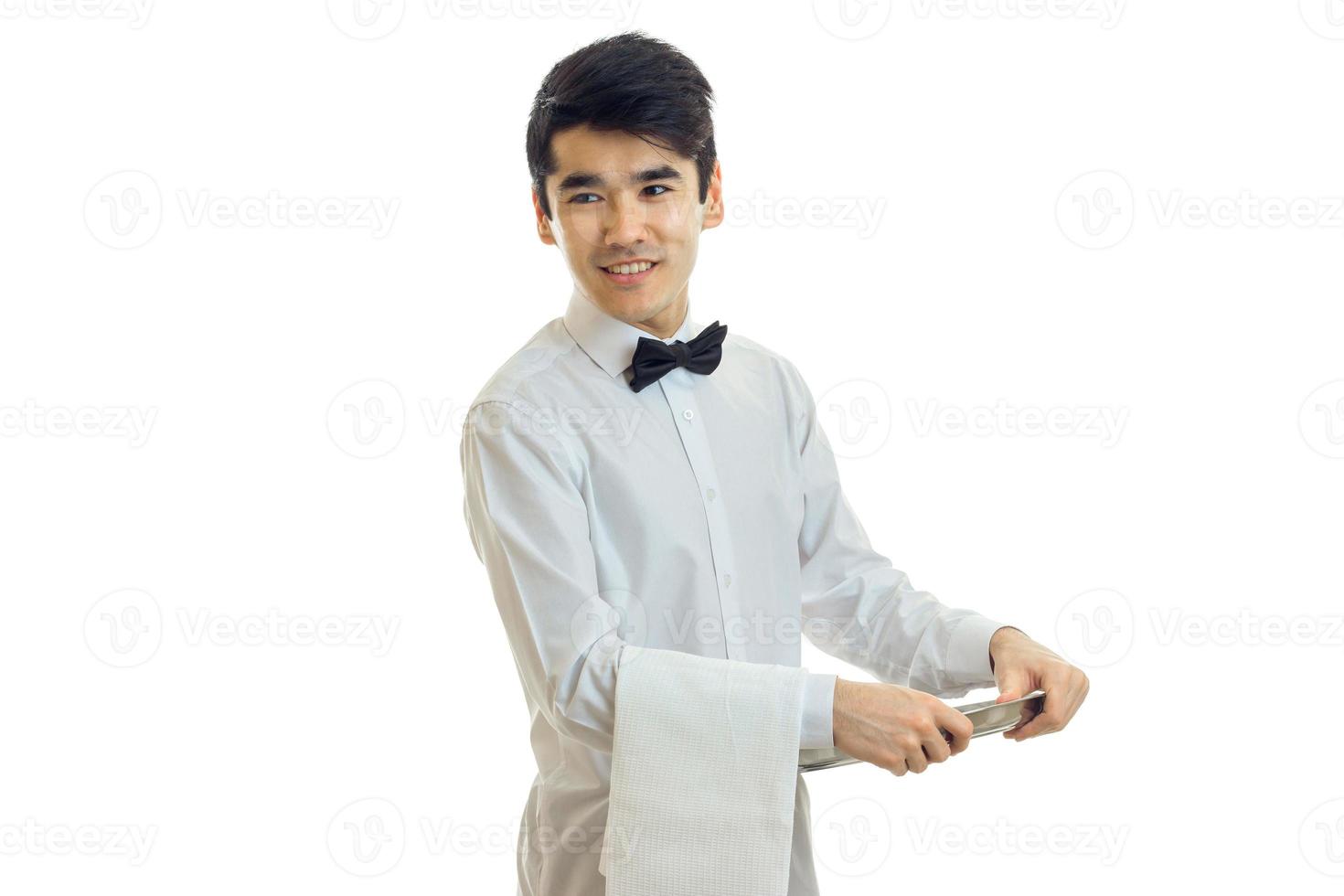 young charming waiter smiling and holding a tray with a towel photo