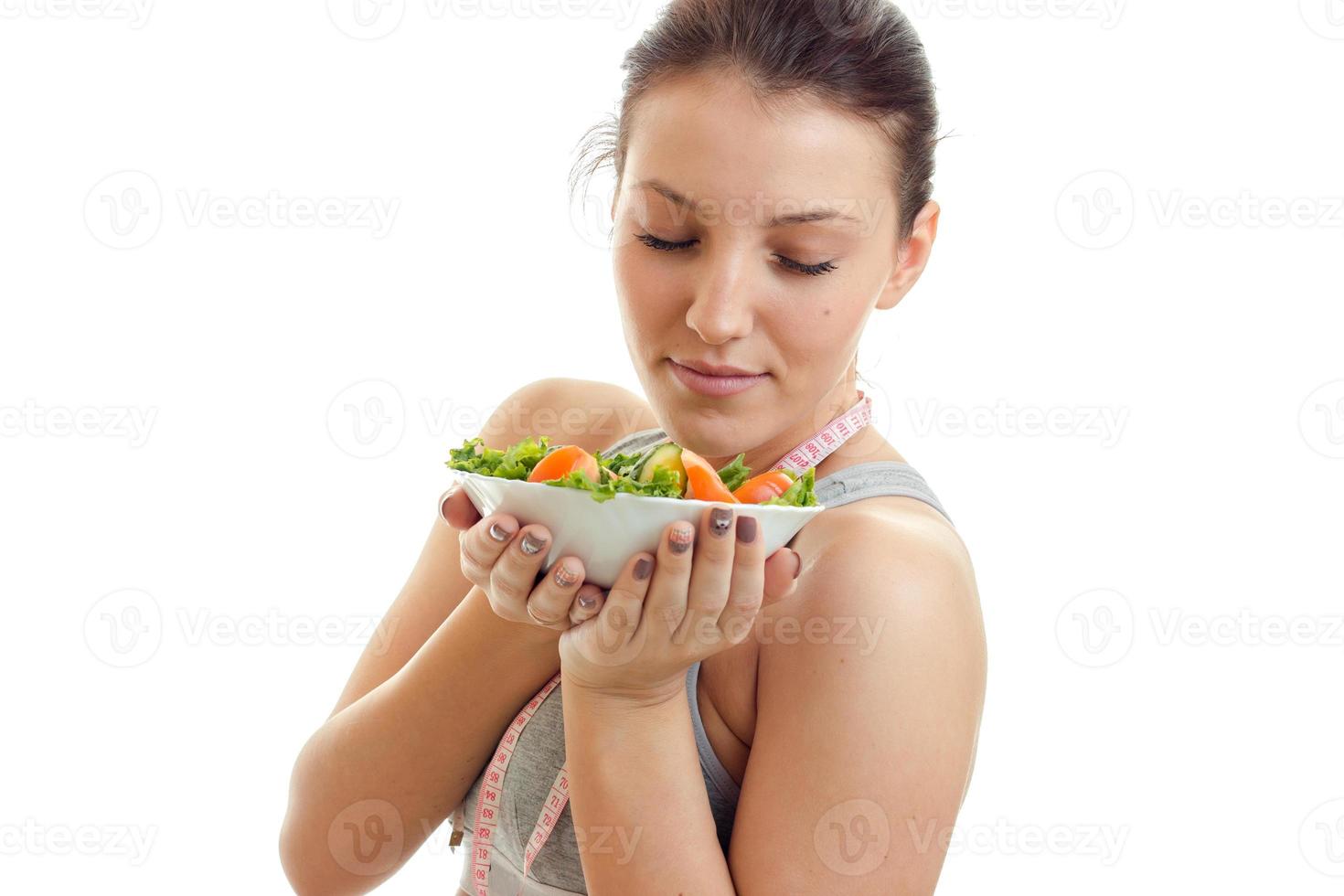 portrait of beautiful young woman with diet food in plate photo