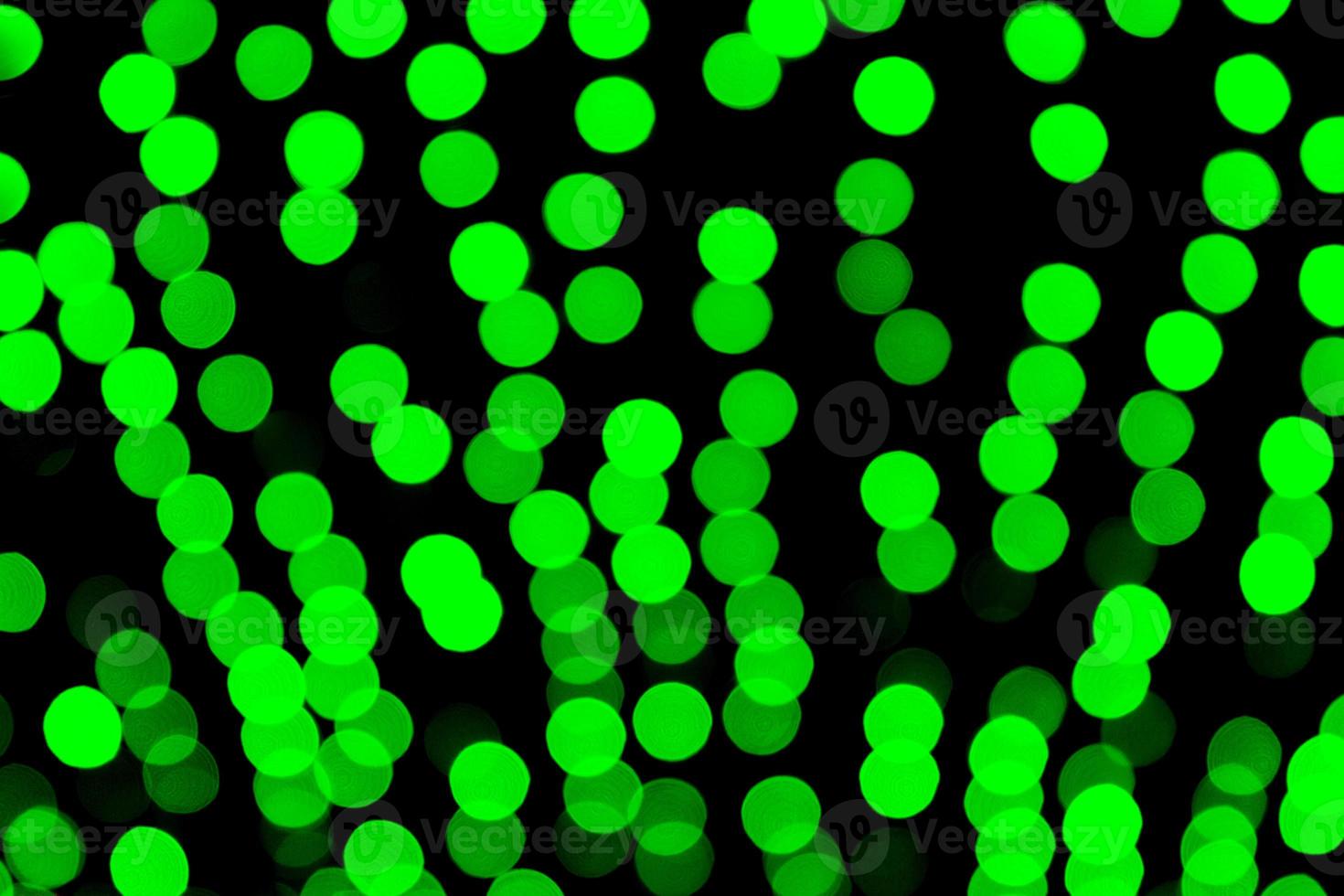 Unfocused abstract green bokeh on black background. defocused and blurred many round light photo