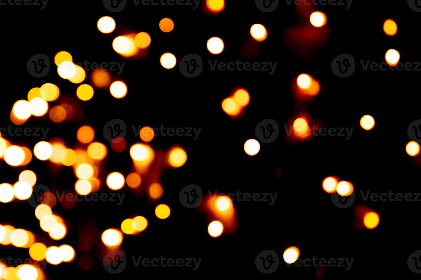 Defocused city gold night bokeh abstract background. blurred many round yellow light on dark background photo