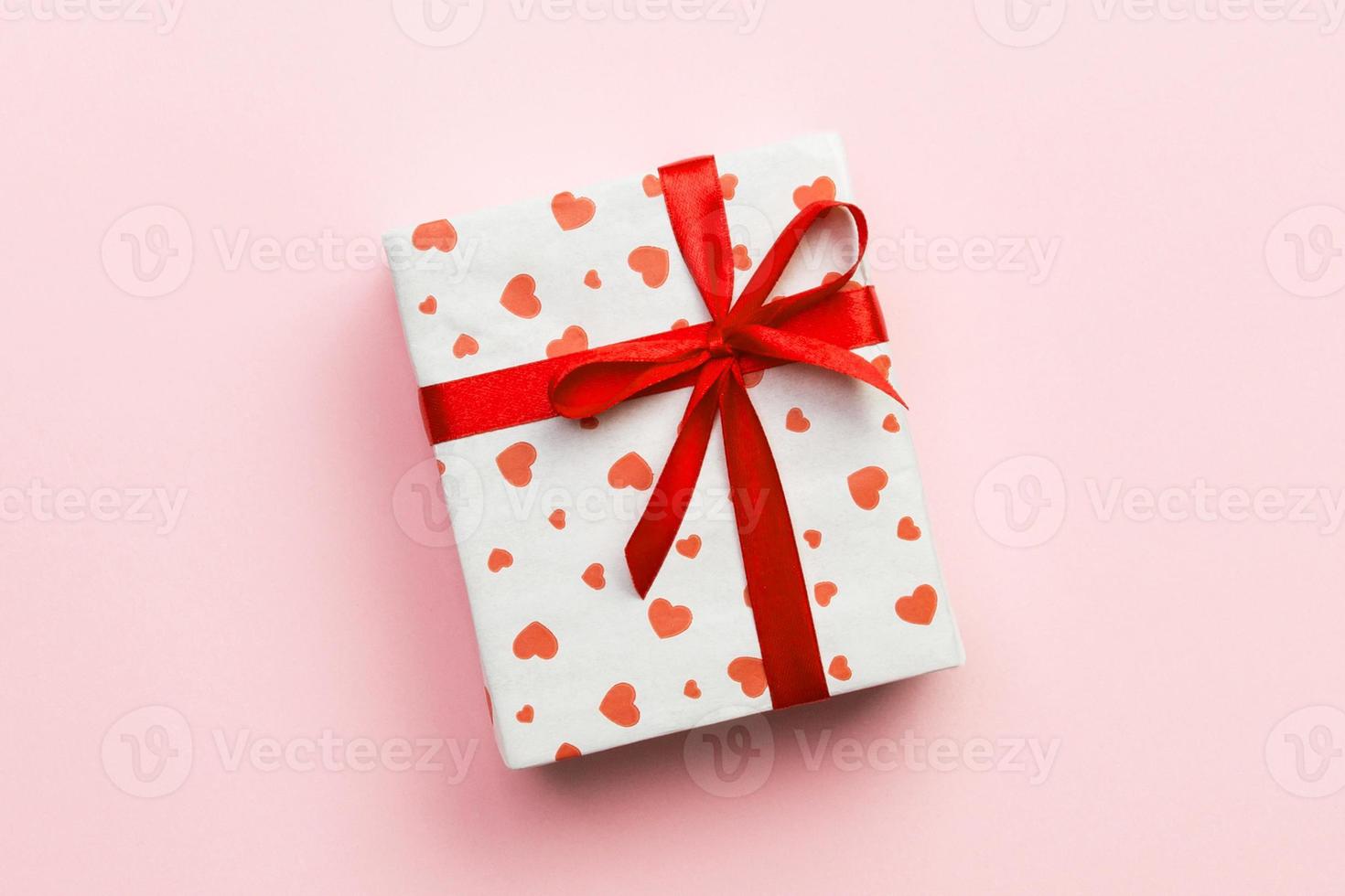 Background with gift box and hearts on rose Background. Top view with copy space for text photo