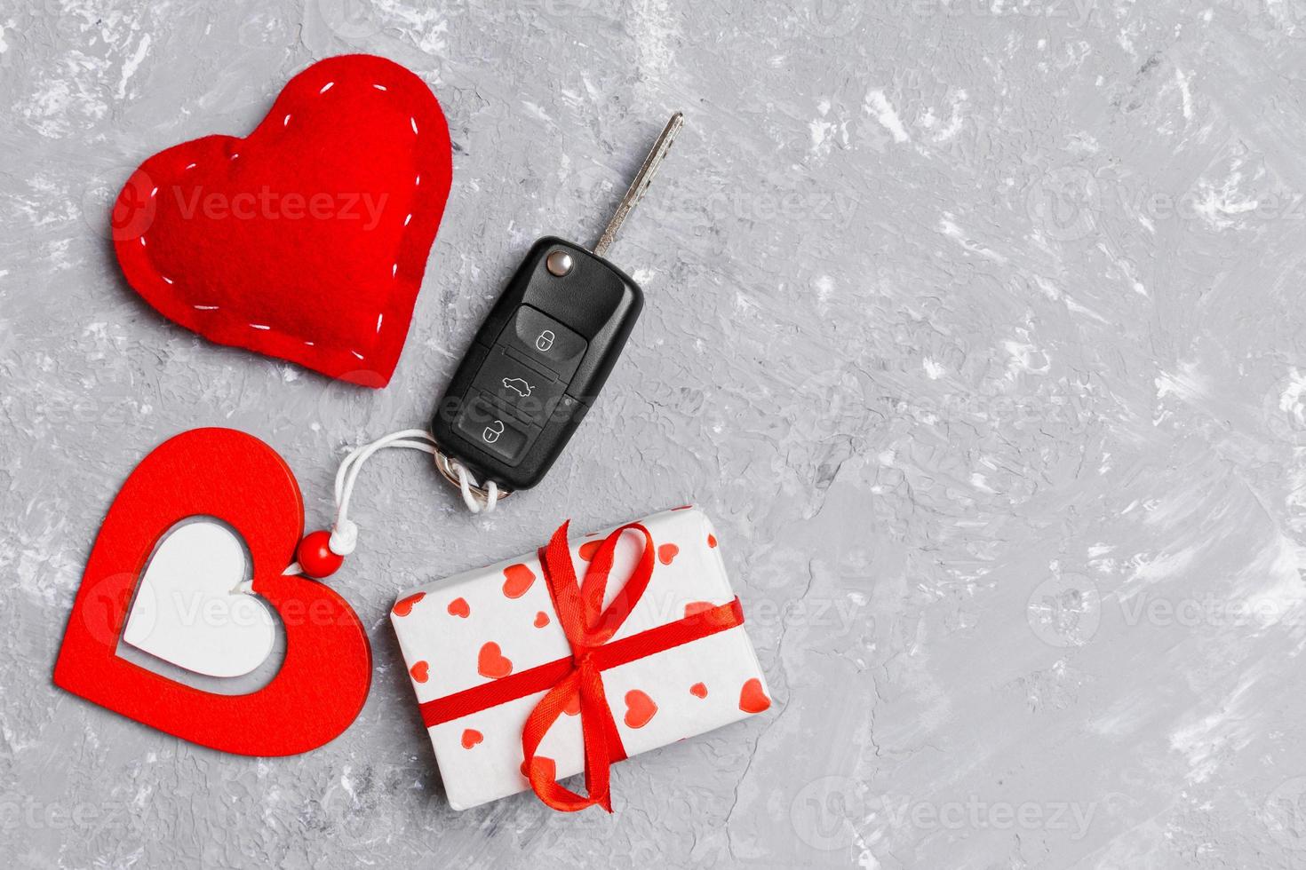 Top view of a present for Valentine's Day on wooden background. Car key, gift box and heart with copy space. Surprise concept for a holiday photo
