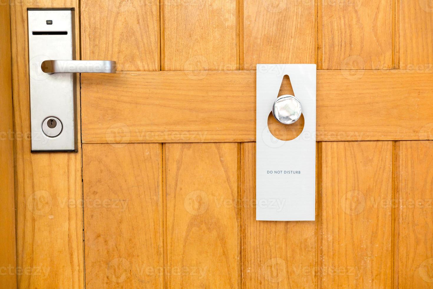 please do not disturb sign on Closed wooden door of hotel room photo