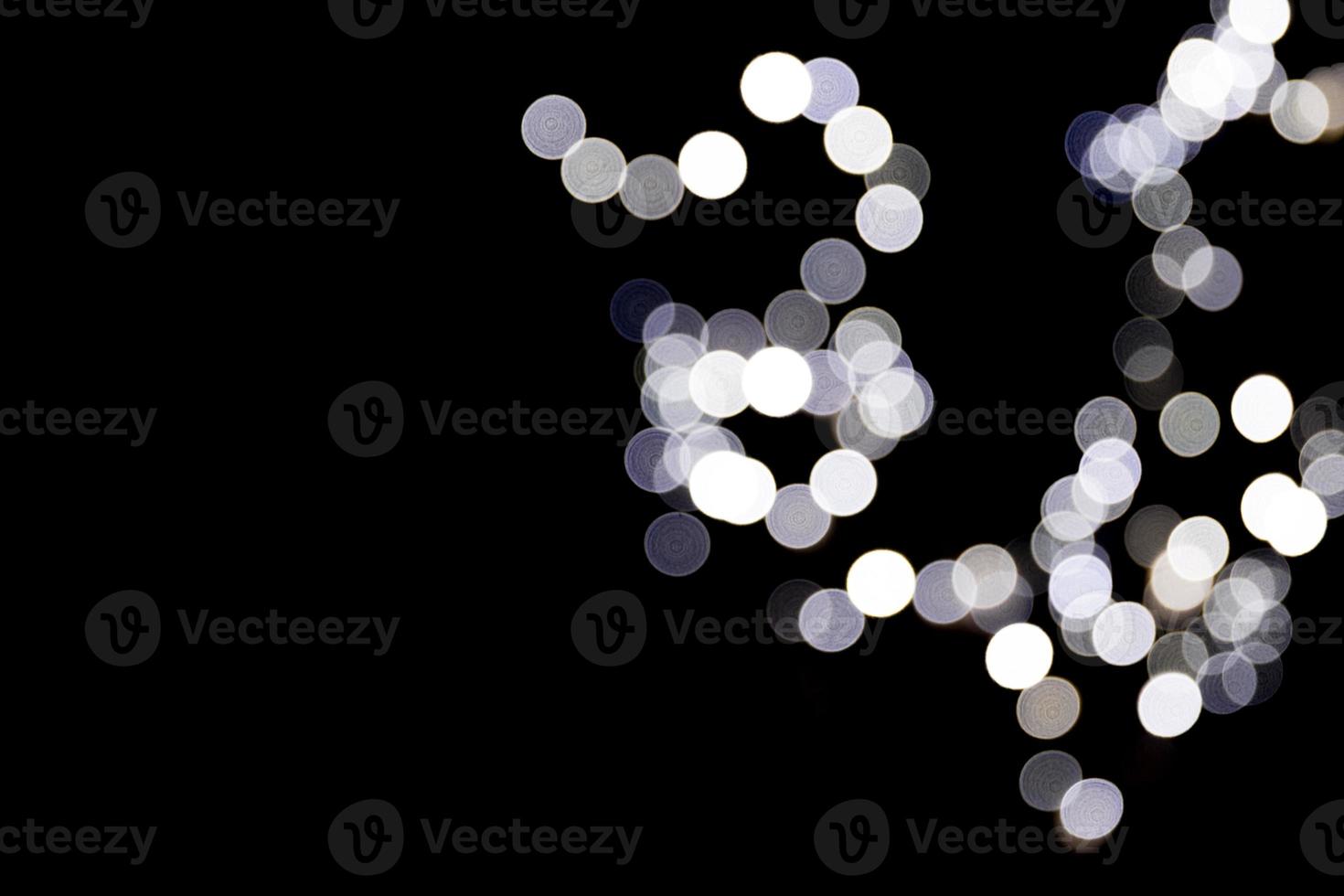 Unfocused abstract white bokeh on black background. defocused and blurred many round light photo