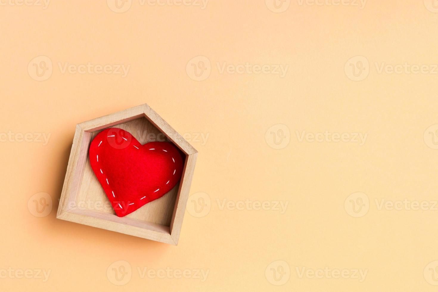 Top view of red textile heart in a wooden house on colorful background. Home sweet home concept. Valentine's day photo