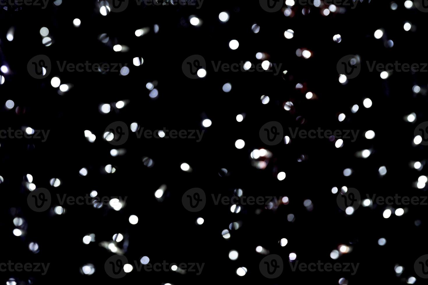 Abstract bokeh of white city lights on black background. defocused and blurred many round light photo