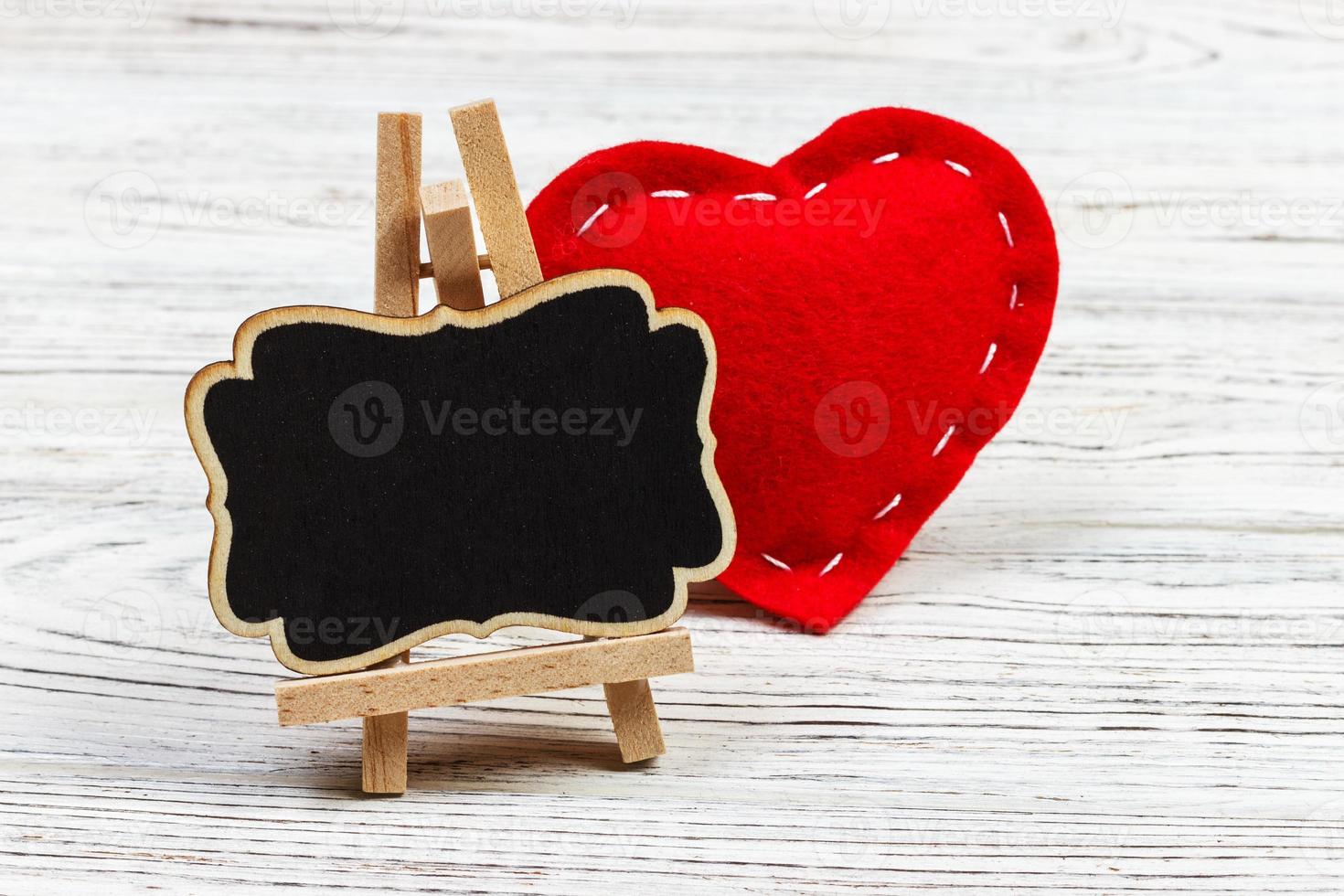 Blackboard on wooden background with red heart. Copy space photo