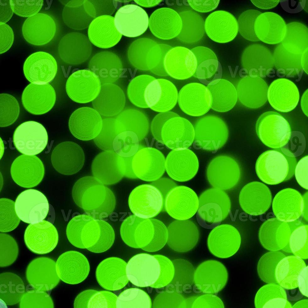 Unfocused abstract colourful bokeh black background. defocused and blurred many round green light photo