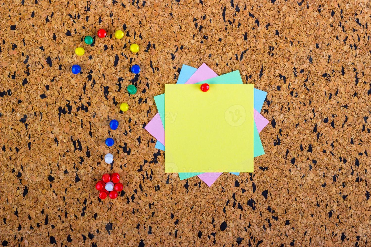 colorful sticky notes on cork bulletin board. Question mark made of pushpins photo