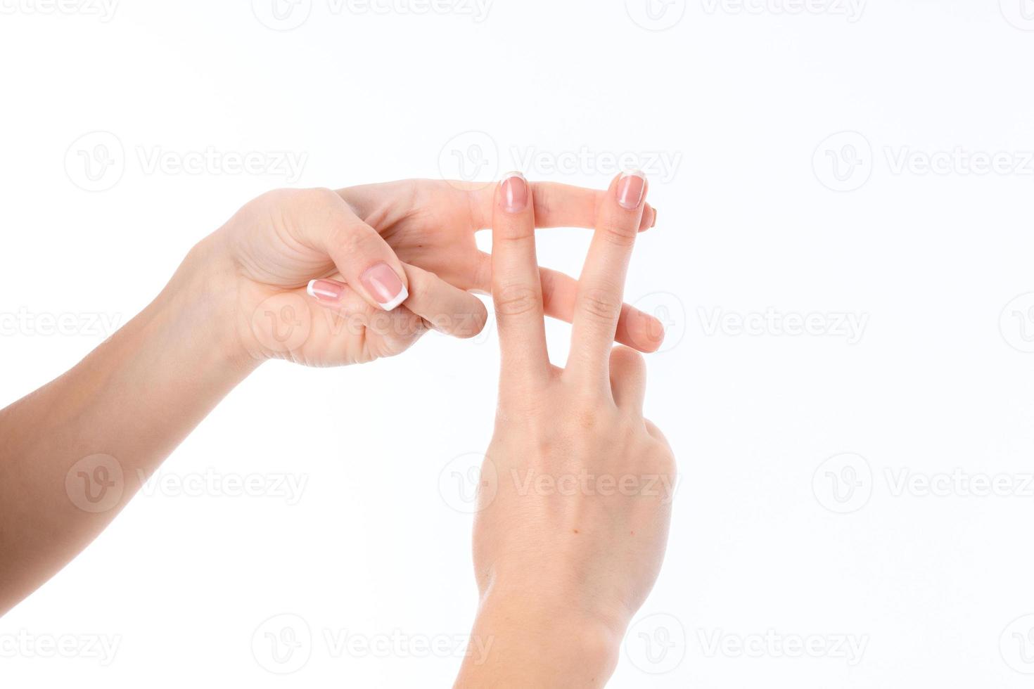 two female hand with crossed fingers between them is isolated on a white background photo