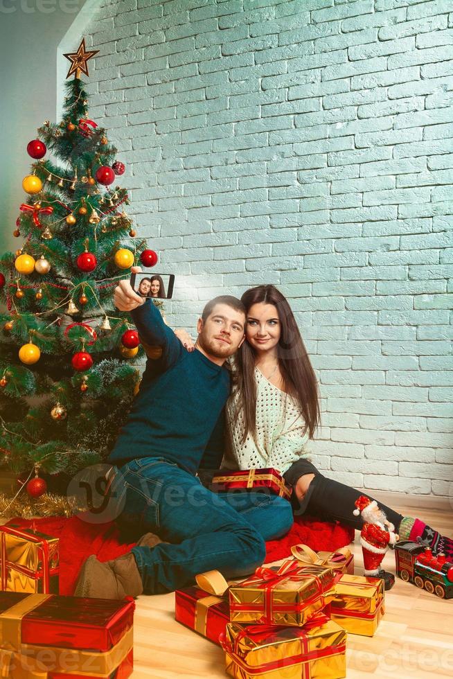 pareja enamorada haciendo selfie navideño foto