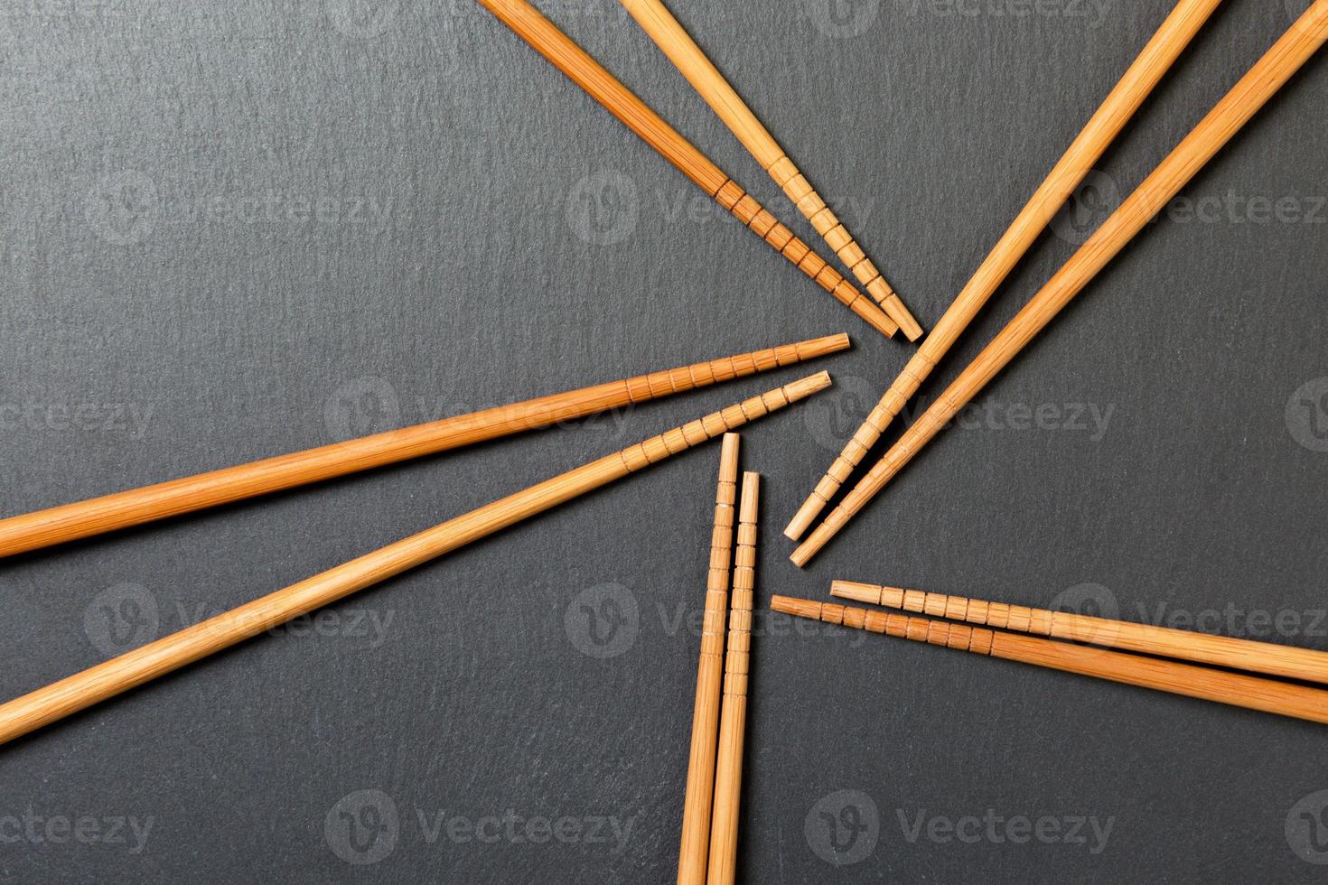 Many bamboo chopsticks on black slate background, textured, top view with opy space photo